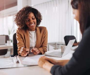 A new employee discusses small business health insurance benefits with her employer.