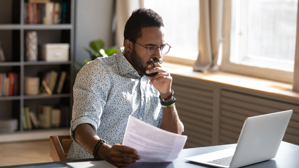 A man reviews documents at a desk, SB 1162 went into effect in California on January 1, 2023.