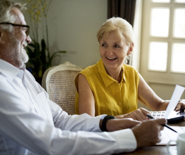 A senior couple reviews 401(k) retirement savings paperwork.