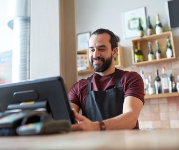 An employee clocks in to begin his shift at a small business.