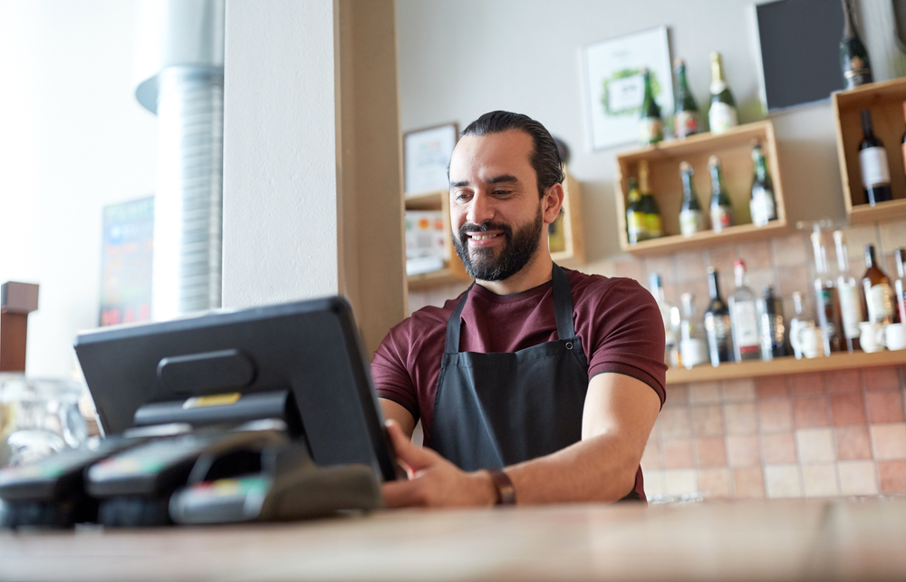 An employee clocks in to begin his shift at a small business.