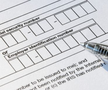 A woman completes an I-9 Employment Eligibility Verification form.