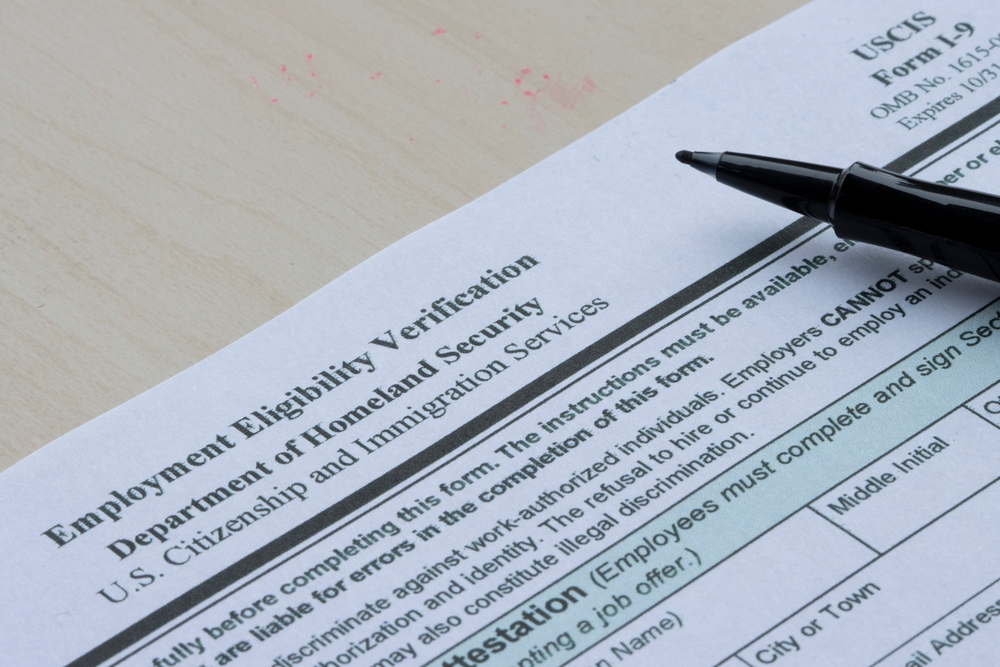 A woman fills out an I-9 Employment Eligibility Verification form.